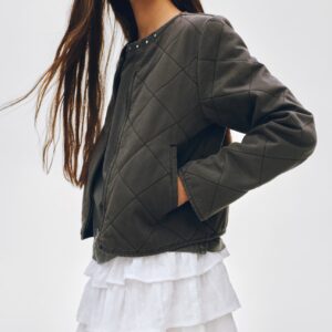 Profil enfant fille portant une veste matelassée kaki dans un univers de mode durable